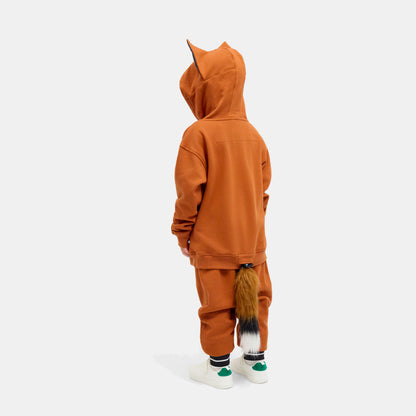 Child seen from behind in the FOXDO Sweatsuit, hood up and the fox tail hanging from the back of the joggers.