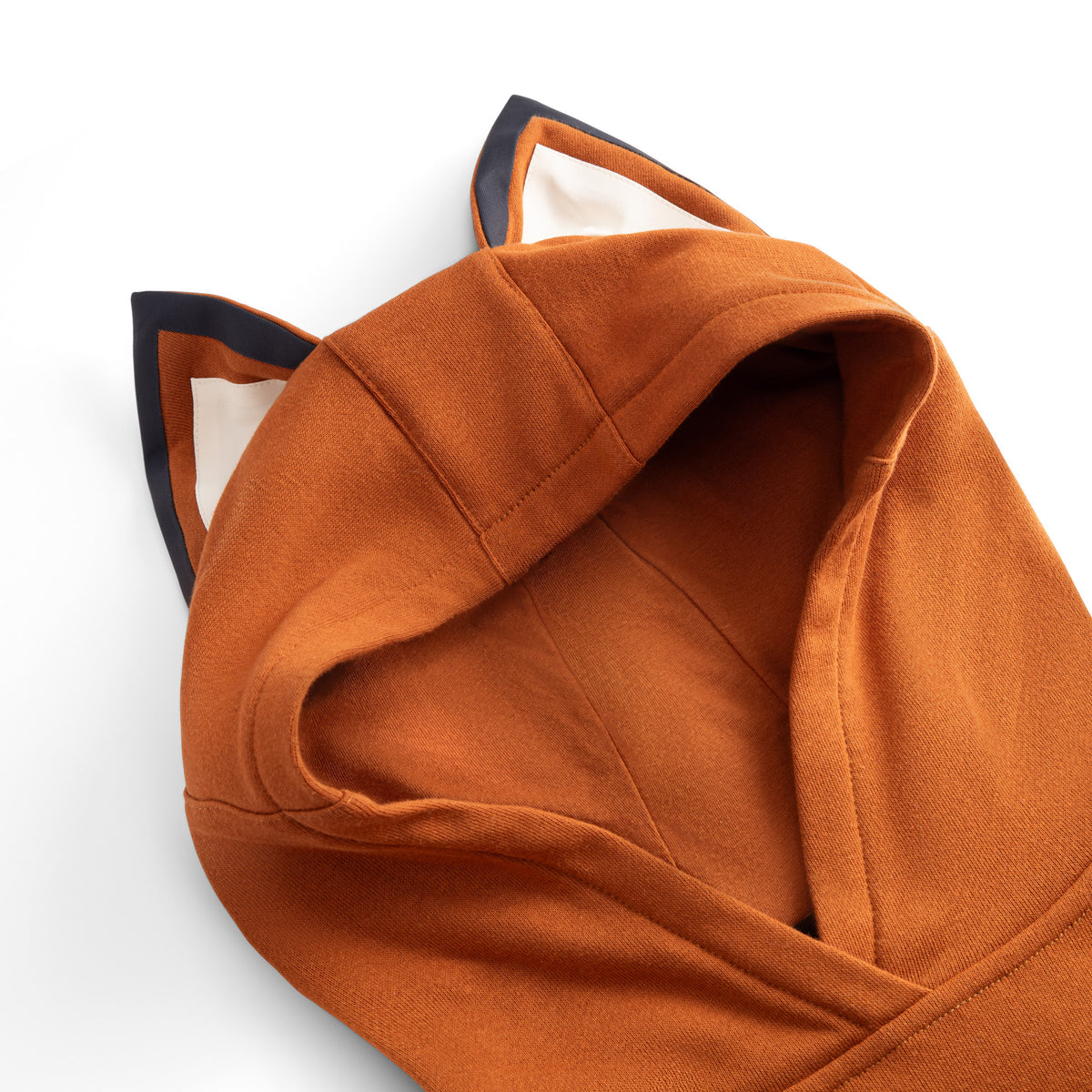 Close-up of the FOXDO hood — fox ears with dark navy edging and a cream inner lining.