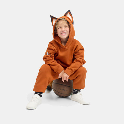 Child sitting on the floor with a ball, wearing the FOXDO Sweatsuit with the hood up.