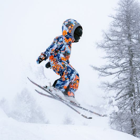 Child skiing in fresh powder in the COSMO SPRAYPRINT Snowsuit